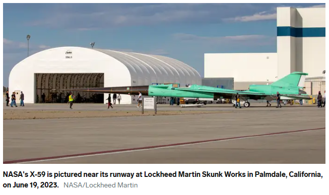 A green jet plane on a runway

Description automatically generated