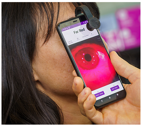 A person holding a phone to her eye

Description automatically generated