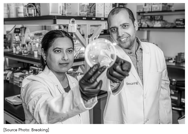 A person and person in lab coats holding a petri dish

Description automatically generated